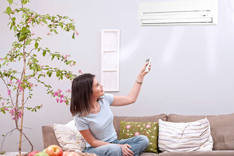 woman using remote control ductless unit